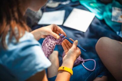 lady making a scarf to illustrate new knitting group