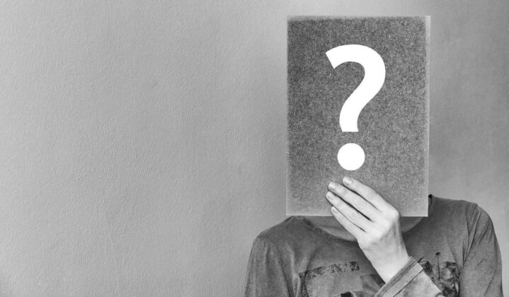 ladies with hearing loss can you help with the study? image is a person holding a question mark card over their face
