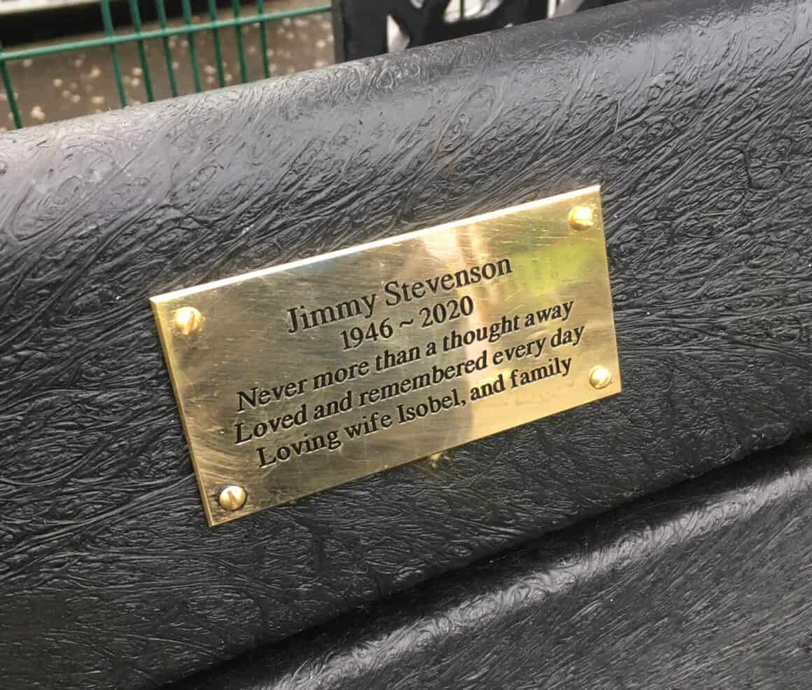 Brass plaque on black bench. Plaque reads "Jimmy Stevenson 1946 - 2020. Never more than a thought away. Loved and remembered every day. Loving wife Isobel and family.
