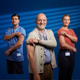 Three people in medical scrubs rolling sleeves up to show where they had injections