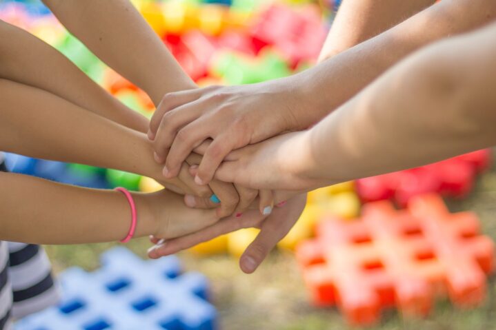 Hands together over puzzle blocks for What's On Groups