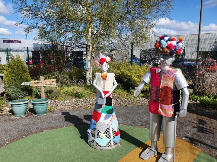 tin lady and man with knitted items on their heads and bodies