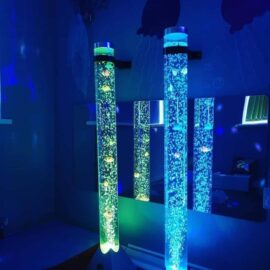 two bubble tubes, one is green, one is blue, there is a mirror behind that reflects the tubes.