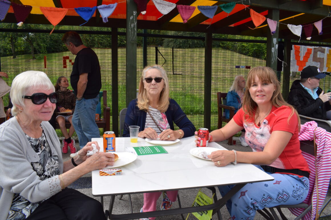 Three people seated enjoying the Summer BBQ