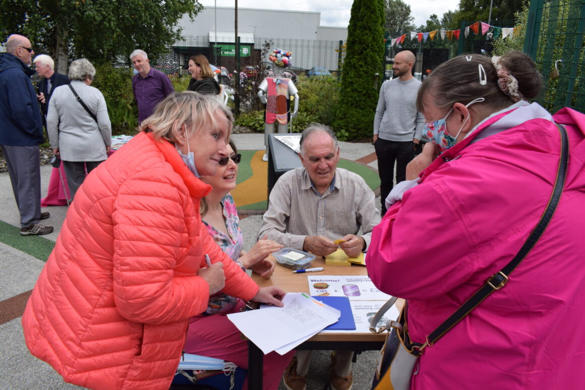 Welcoming people to the event (several people seated and standing)