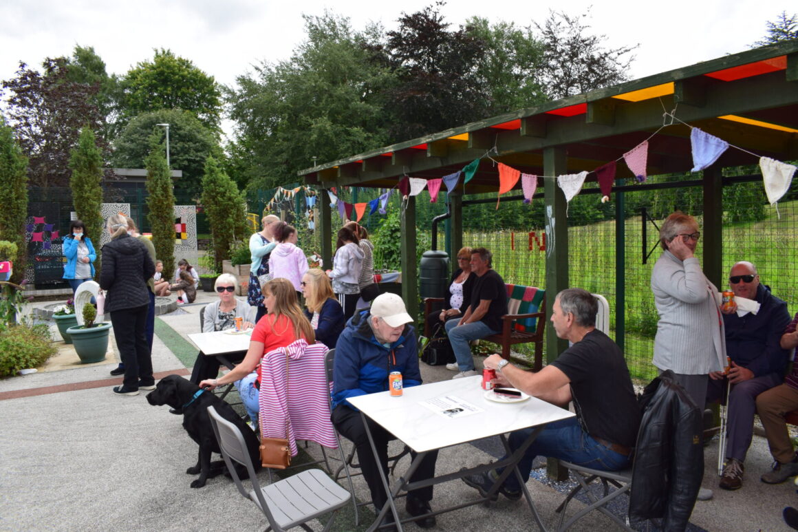 People seated in and in front of our garden shelter