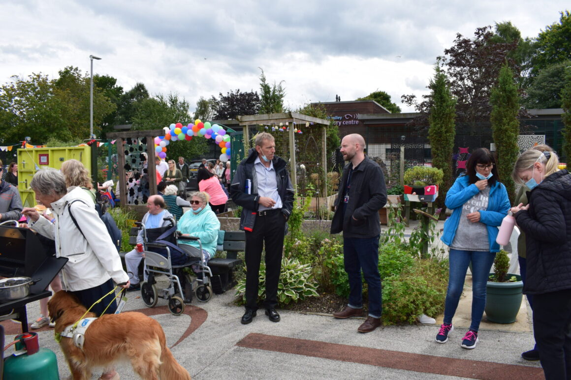 Two people from Blind Veterans UK with lots of other people surrounding them at the edges of the picture