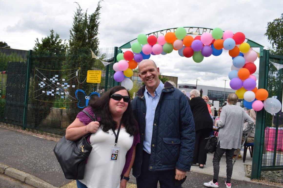 Margaret and Campbell from RNIB with balloon arch in the background