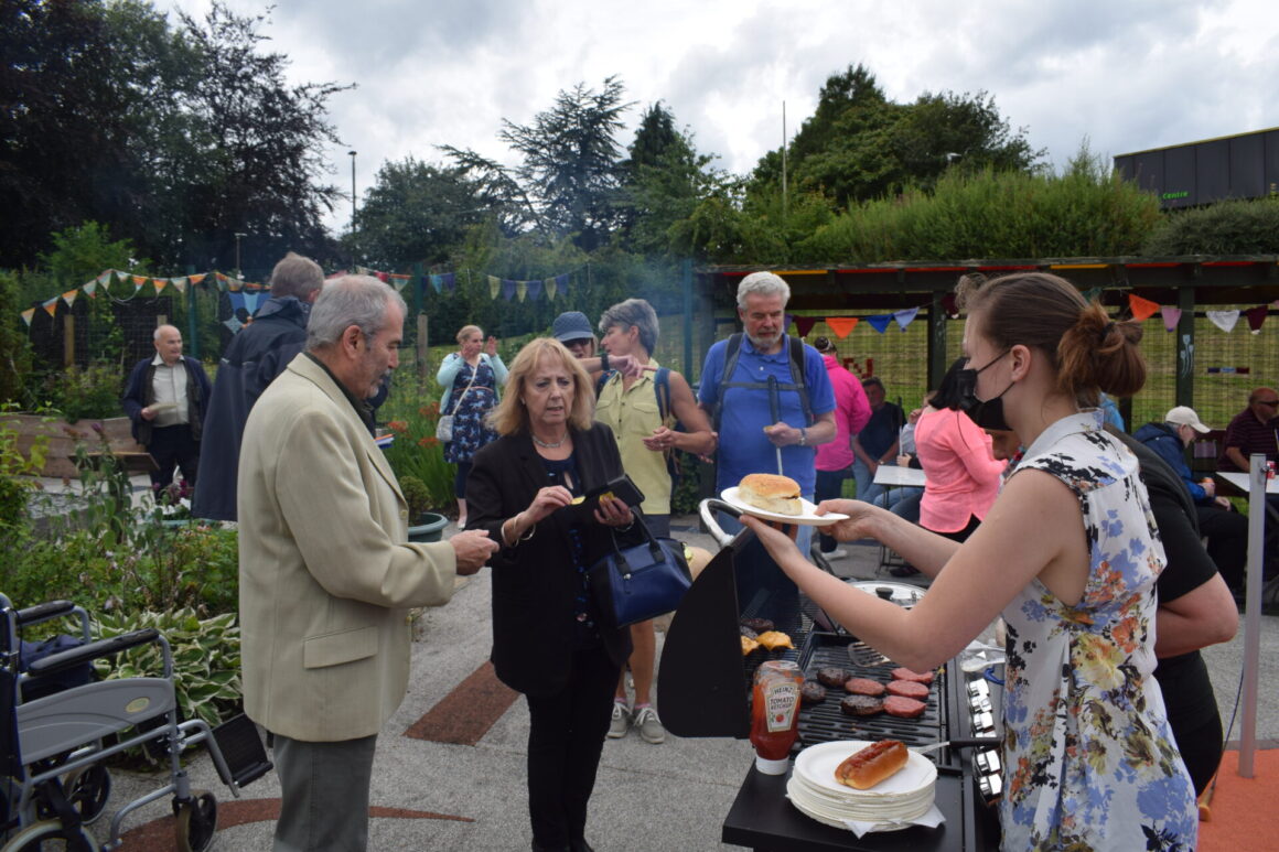 Rowan serves a burger with lots of people in background