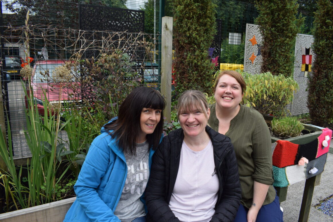 Three ladies seated in Sensory Garden at the Summer BBQ
