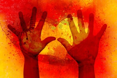 Silhouette hands over a glowing orange heart