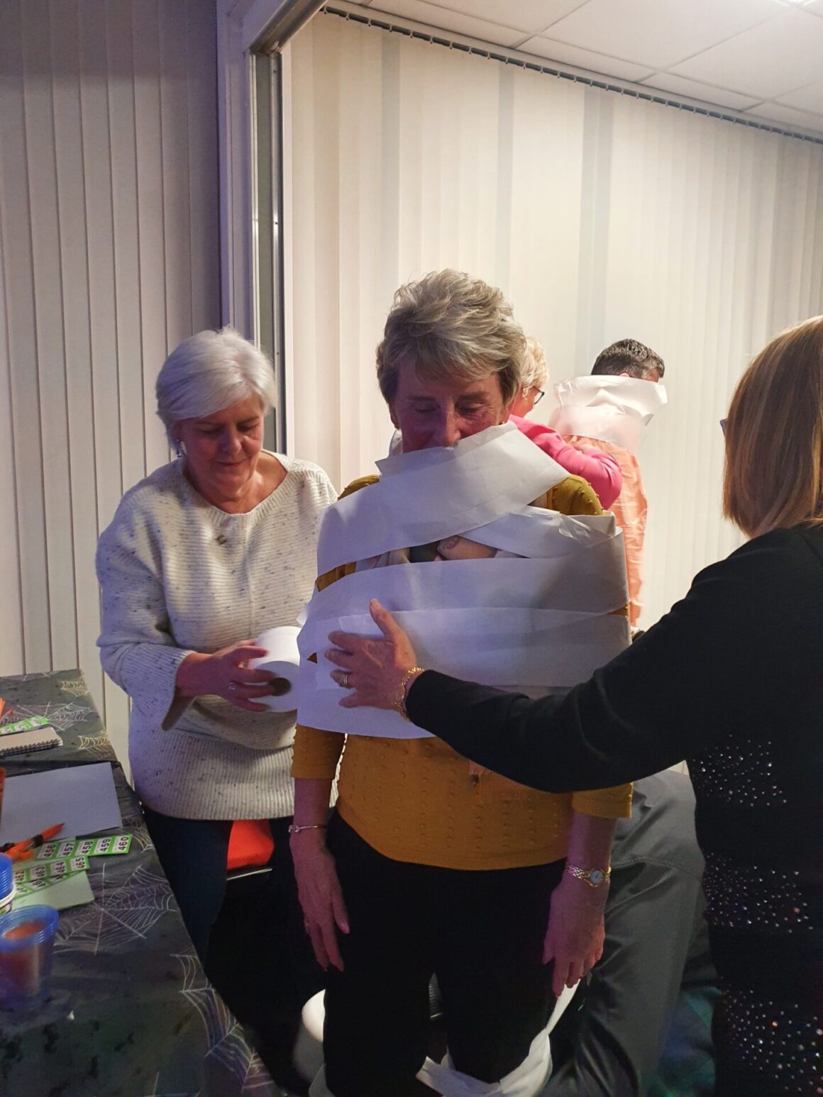 Two people wrapping a third