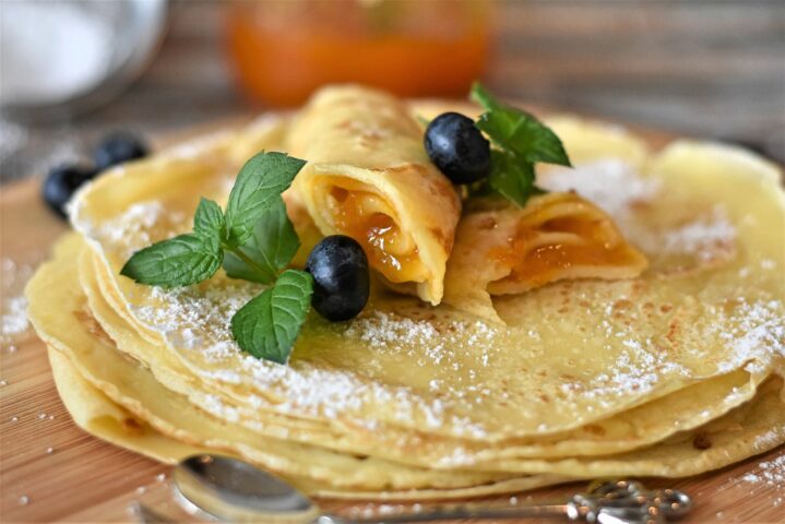 stack of pancakes with syrup filling and garnish