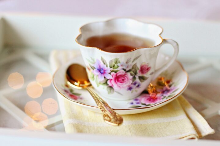 A floral tea cup and saucer with silver spoon