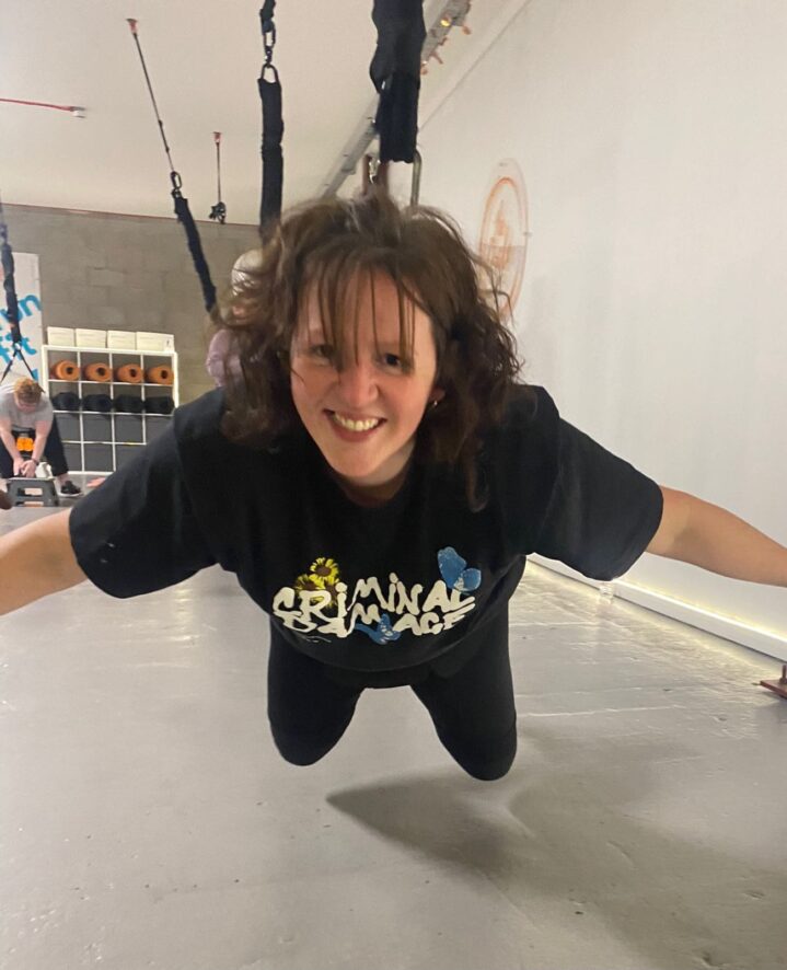Sally taking part in bungee fly, she is strapped to a harness and doing a 'mission impossible' stance.