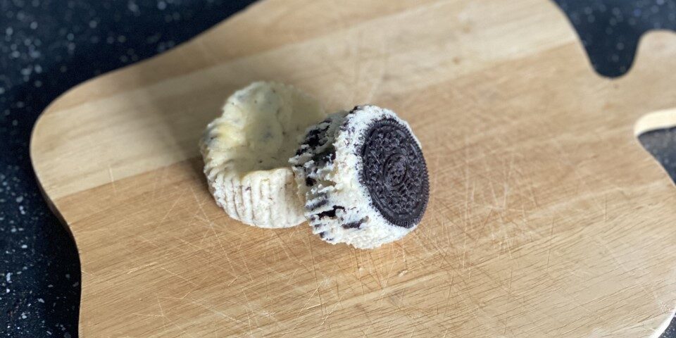 two oreo cheesecakes on an apple shaped chopping board